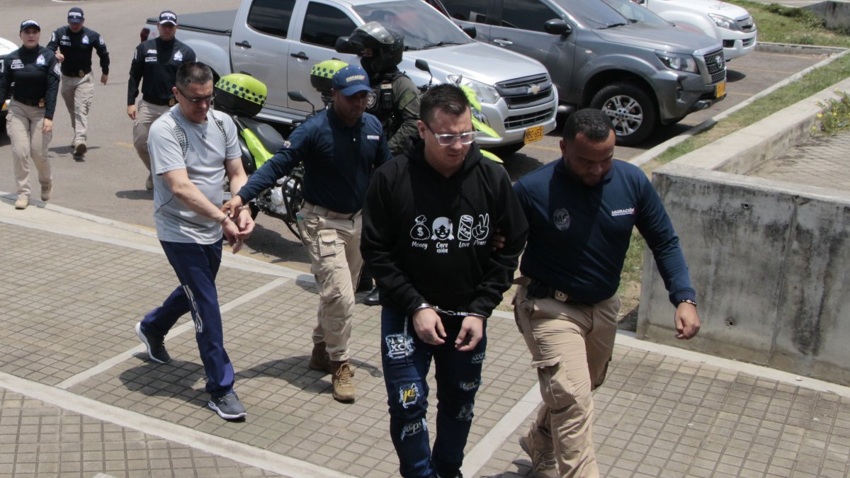 Agentes de Migración Colombia y de la Dirección de Investigación Criminal e Interpol (Dijin) reciben a Oscar Alexander Portilla (c) junto a otros deportados desde Venezuela.