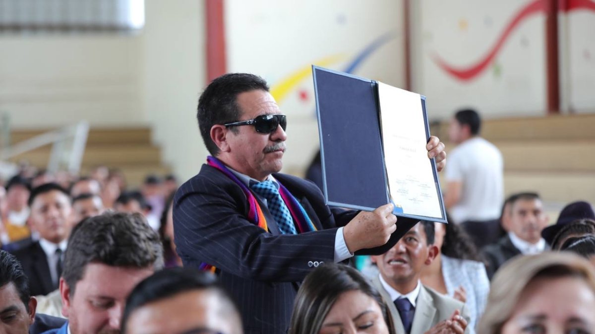 Acto. Una de las autoridades electas muestra su credencial, en Cañar.