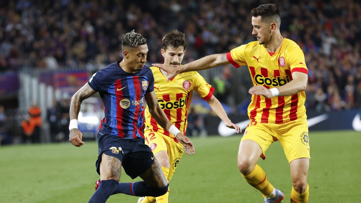 El atacante brasileño del Barcelona Raphinha (i) disputa una posesión con el centrocampista Toni Villa (c) y su compañero Javi Hernández, del Girona.