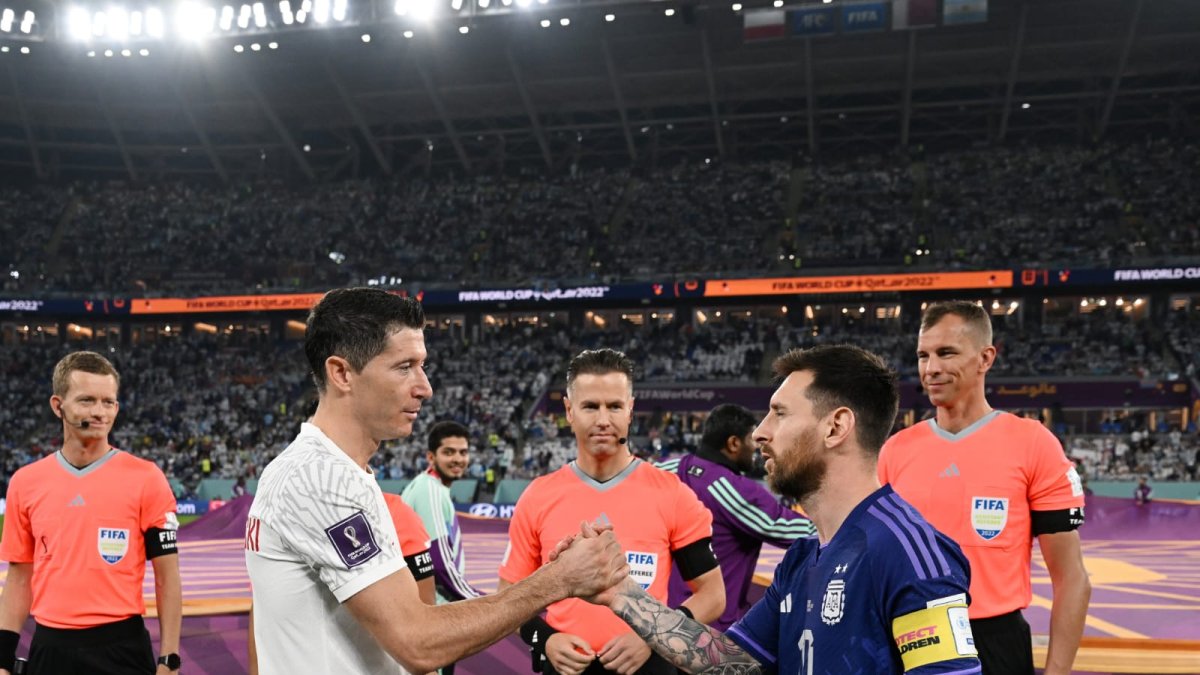 Lewandowski (i) y Messi estrechan saludo durante la Copa del Mundo de Qatar 2022.