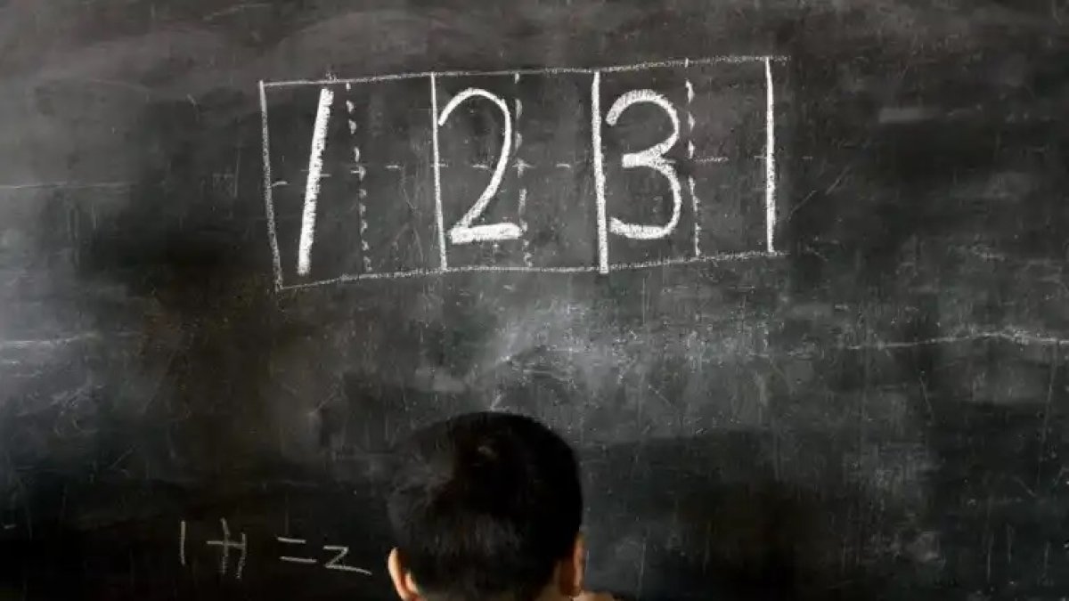 Aulas. Un niño hace ejercicios de matemáticas en la pizarra.