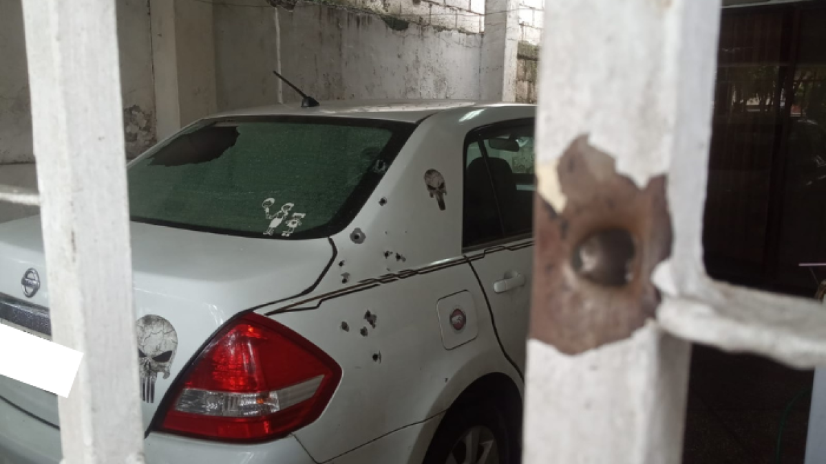 Las rejas de la puerta y la parte trasera de un vehículo quedaron con orificios de proyectiles.