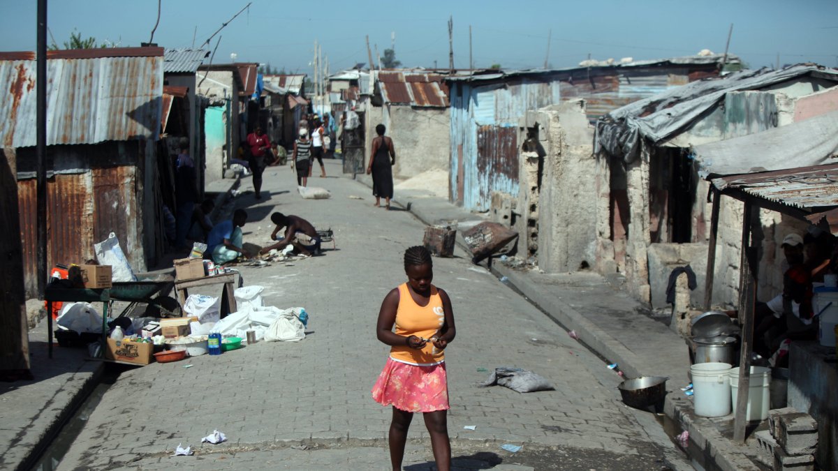 Imagen de archivo de una mujer camina por una calle en el barrio Cité Soleil de Puerto Príncipe (Haití).