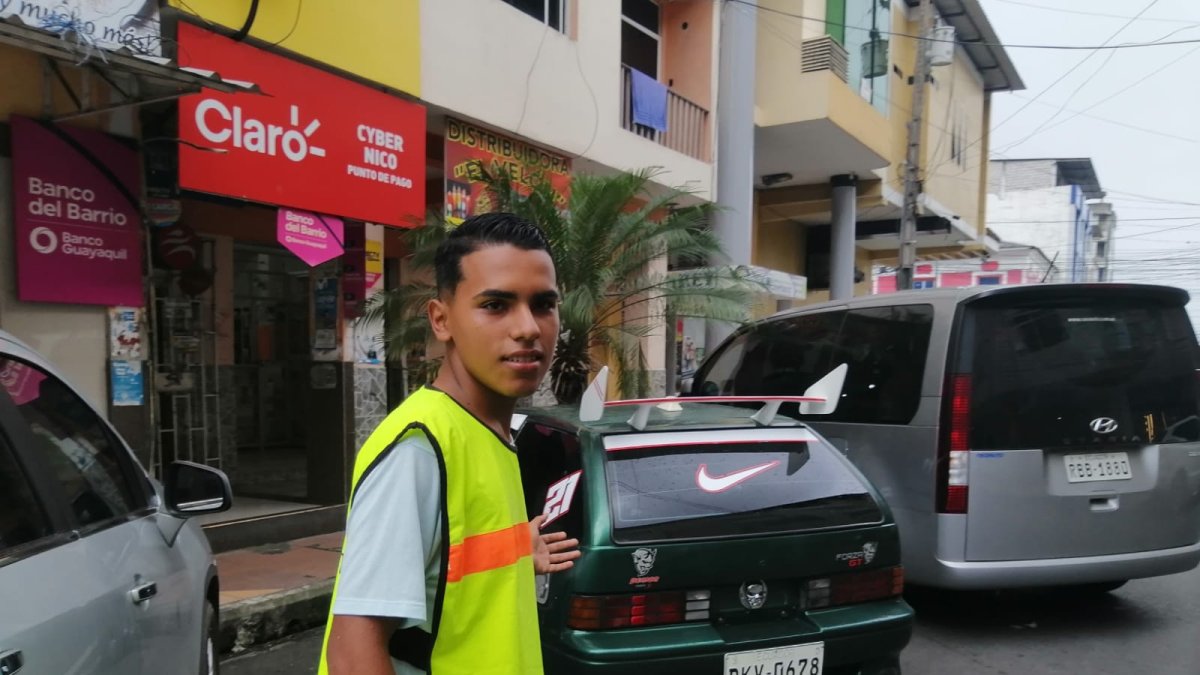 Jornada labora. Kevin recorre una de las calles del centro de Quevedo, donde cuida carros. Es su punto de trabajo.