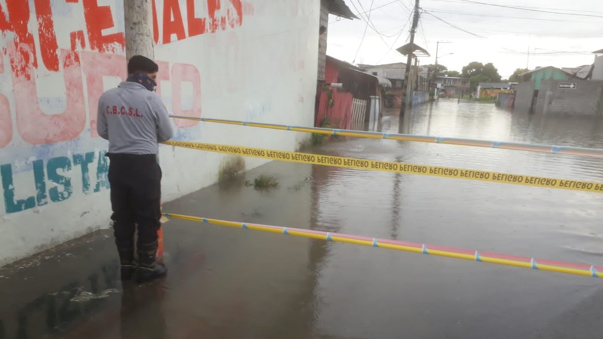Personal del Cuerpo de Bomberos señaliza algunas zonas inundadas para evitar el paso de las personas y posibles accidentes