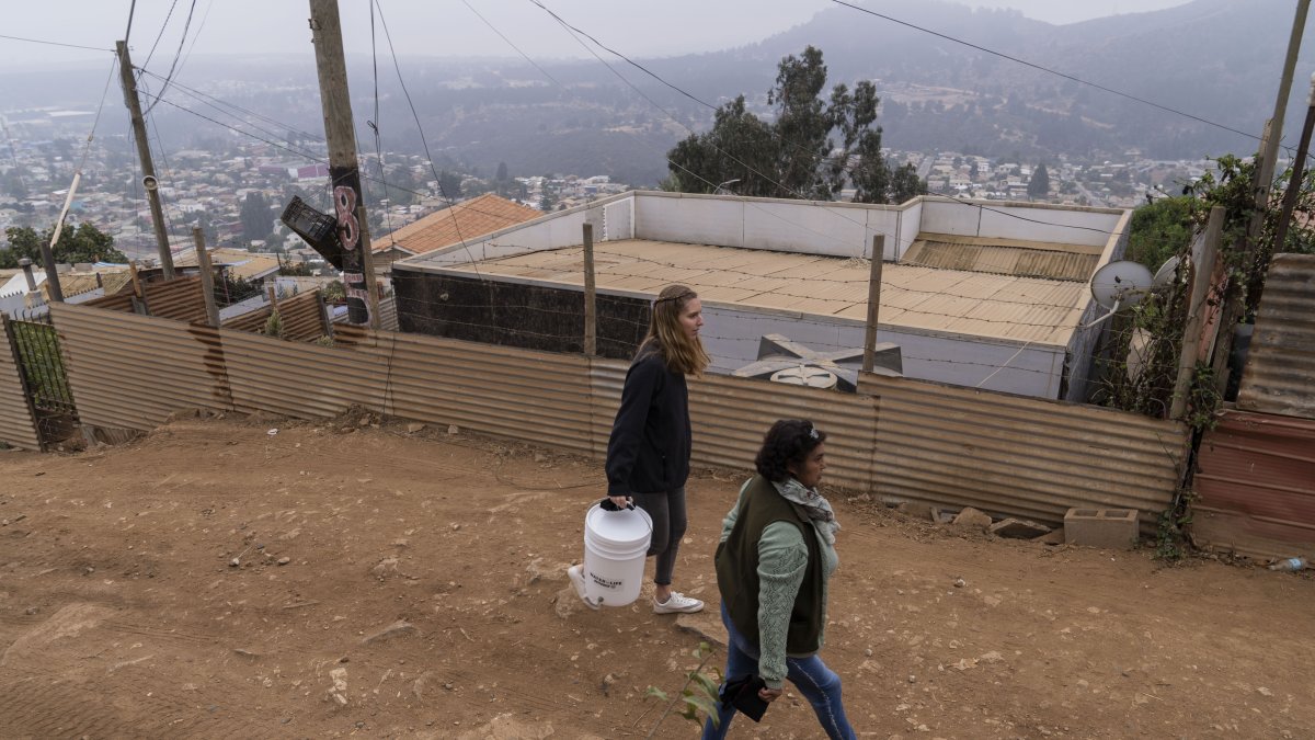 Recorrido. Emilia Venegas (d), dirigente comunitaria, y María Paz Valdivia, de la ONG, caminan por una calle local.