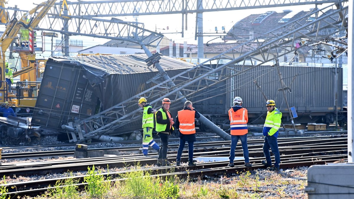 Trabajadores junto al tren de mercancías descarrilado cerca de una estación en la ciudad italiana de Florencia.