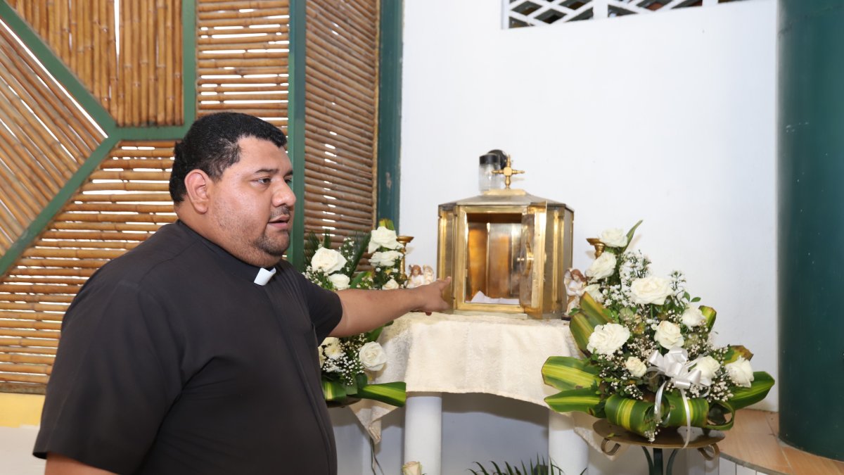 El sacerdote César Chiriboga muestra la urna que fue vulnerada por los hampones que se llevaron hasta el Santísimo Sacramento.
