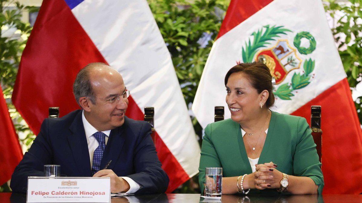 La mandataria Dina Boluarte mientras habla con el expresidente mexicano Felipe Calderón, durante una conmemoración de los 12 años de la Alianza del Pacífico, en el Palacio de Gobierno en Lima.
