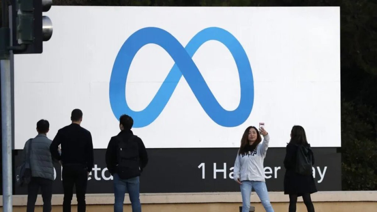 Símbolo.- Un grupo de personas ante el logo de la empresa Meta.