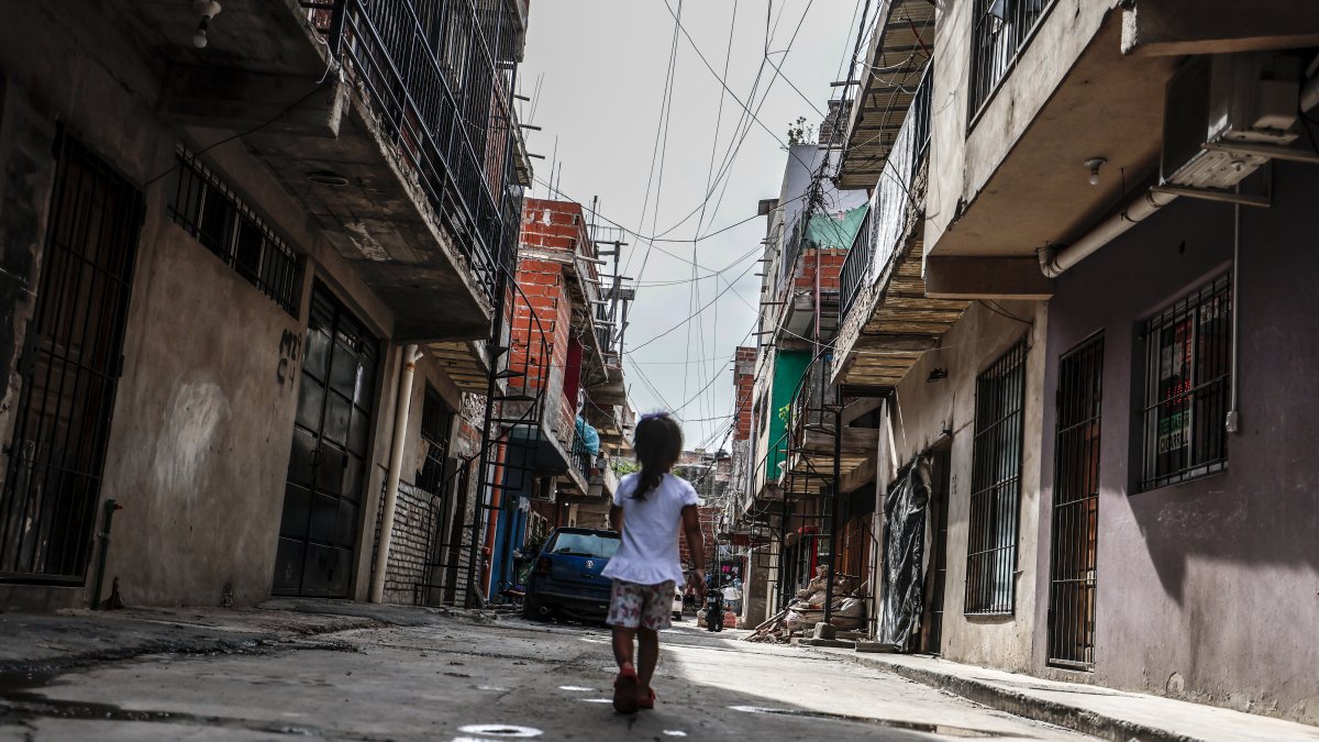 Hecho. Una niña  atraviesa la calle de una de las villas en la Ciudad de Buenos Aires.