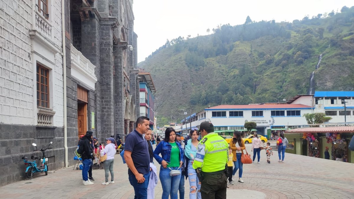 Medida. Un policía conversa con visitantes, en un sitio turístico.