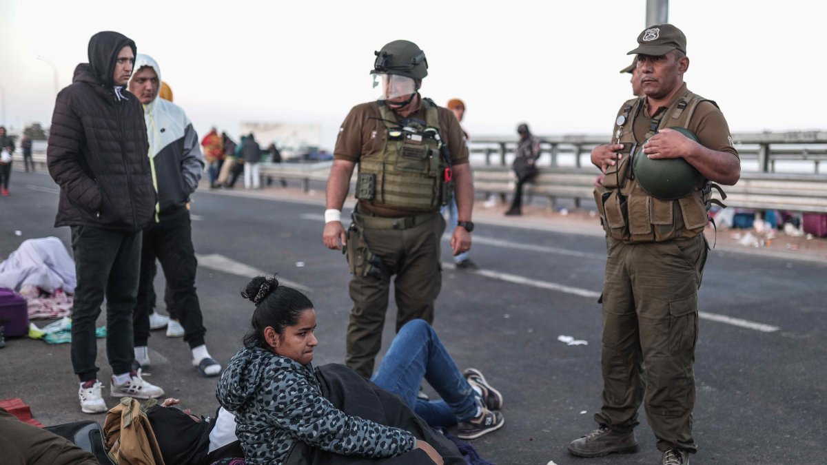 Policías hablan con migrantes en el paso fronterizo de control entre Santa Rosa (Perú) y Chacalluta (Chile), el jueves 27 de abril de 2023.  
