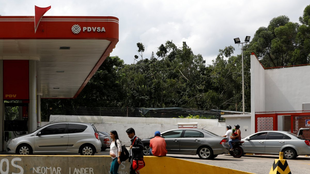 Estación.- Los peatones caminan junto a una estación de servicio de la petrolera estatal venezolana PDVSA en Caracas, Venezuela.