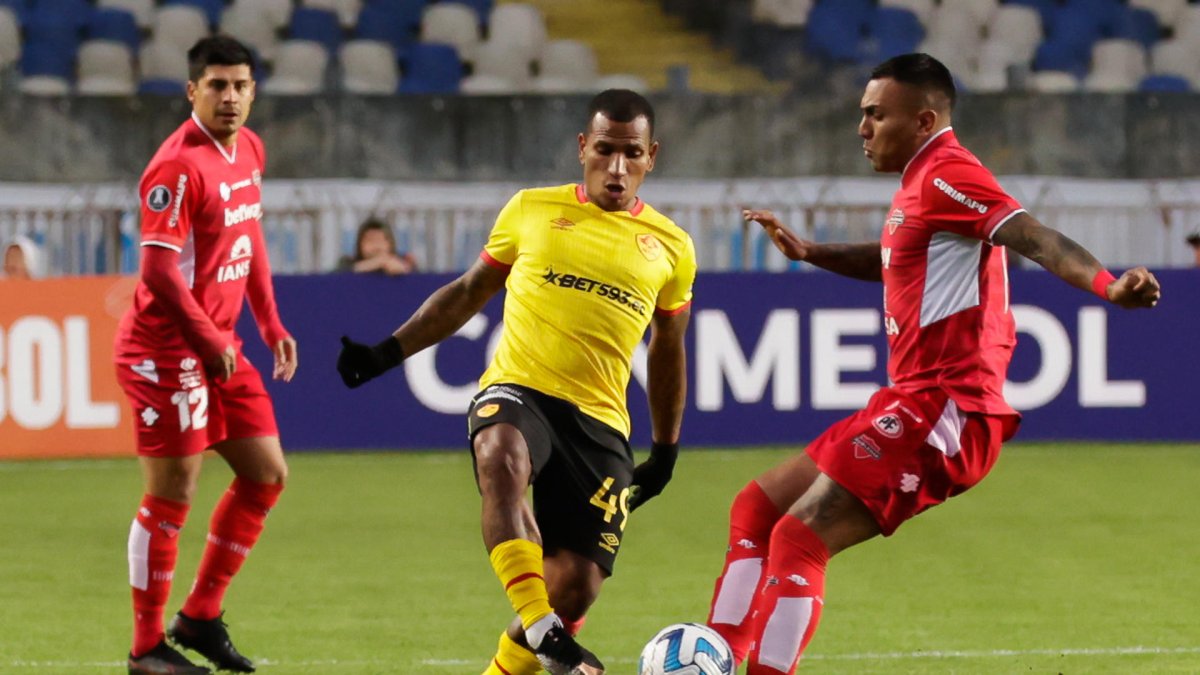 Juan Leiva (d) de Ñublense disputa el balón con Rómulo Otero de Aucas