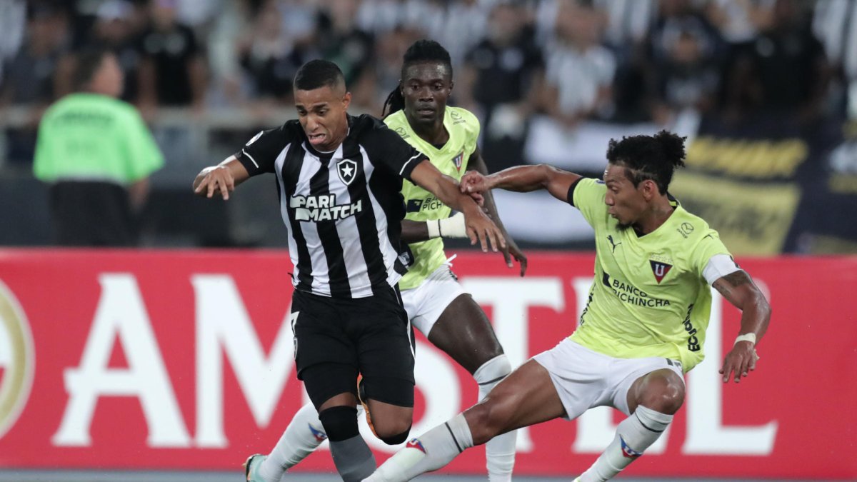 João Victor (i) de Botafogo y José Quintero de Liga de Quito disputan un balón.