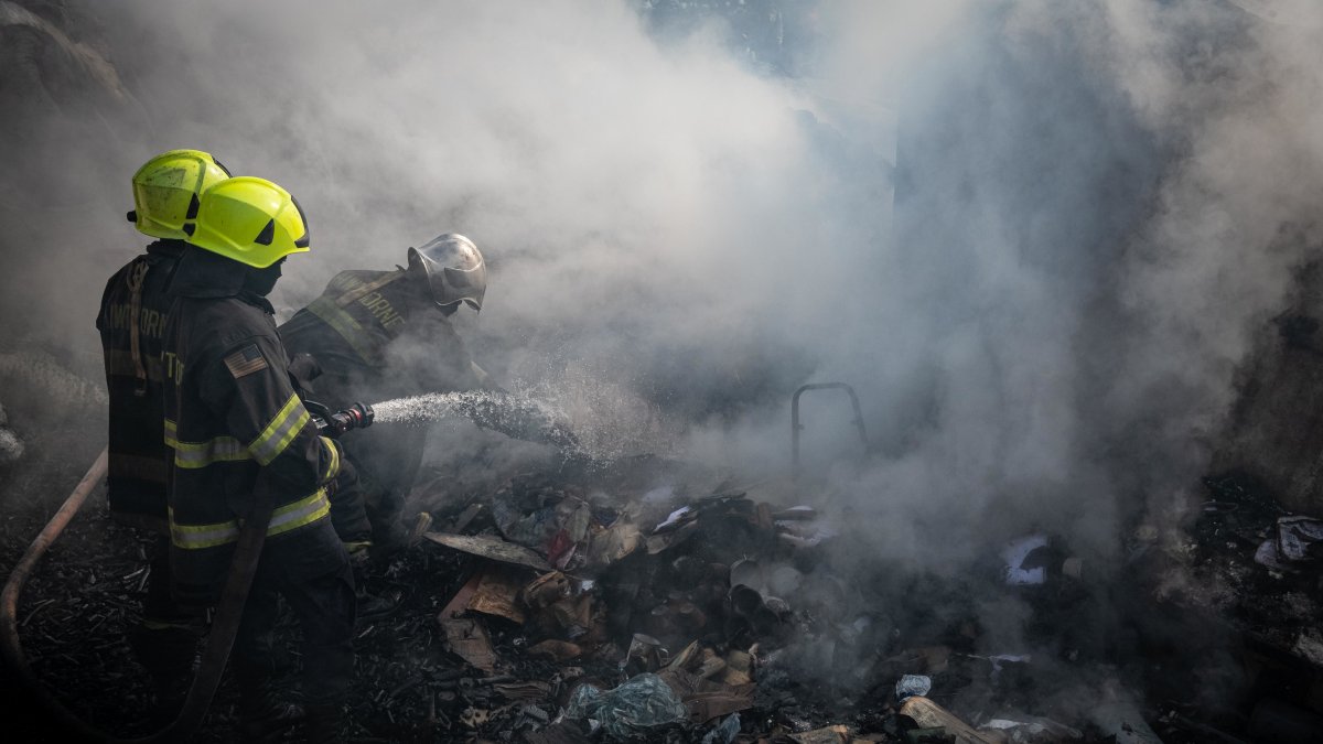 Los  bomberos tratan de sofocar las llamas en el mercado