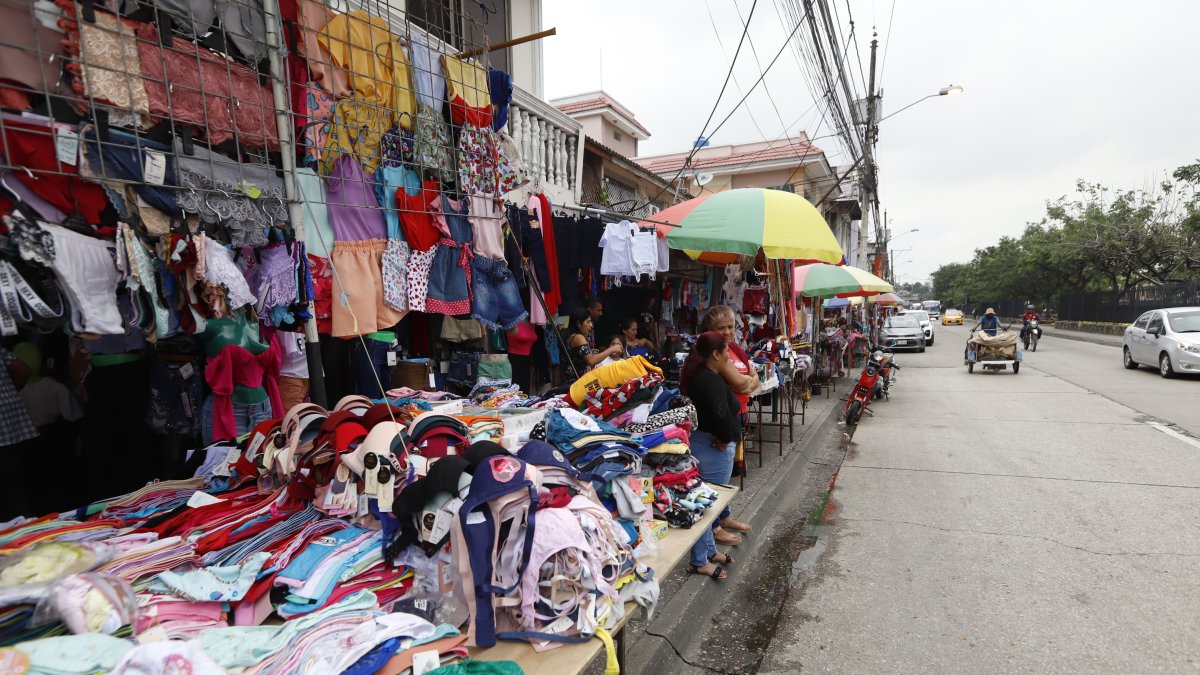 Informalidad. Los negocios de ropa se toman las veredas de zonas del norte. Las personas deben caminar al borde de la acera.