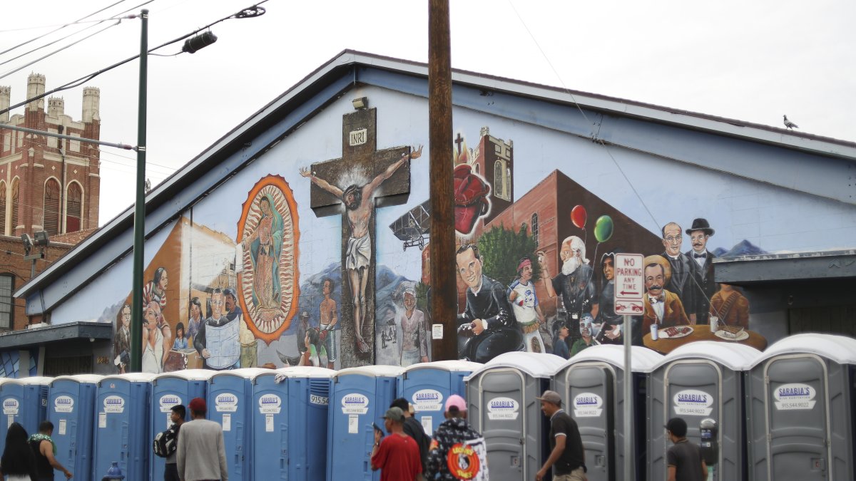 Tránsito. Migrantes usan baños portátiles, en un acampado en los alrededores de la iglesia Sagrado Corazón, en el área central de El Paso.