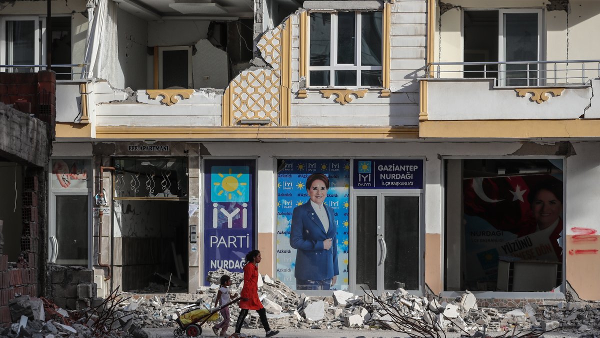 Tránsito. Una mujer con su hija caminan entre las ruinas que ha dejado el sismo y que aún no han podido desalojarse en la ciudad de Nurdagi.