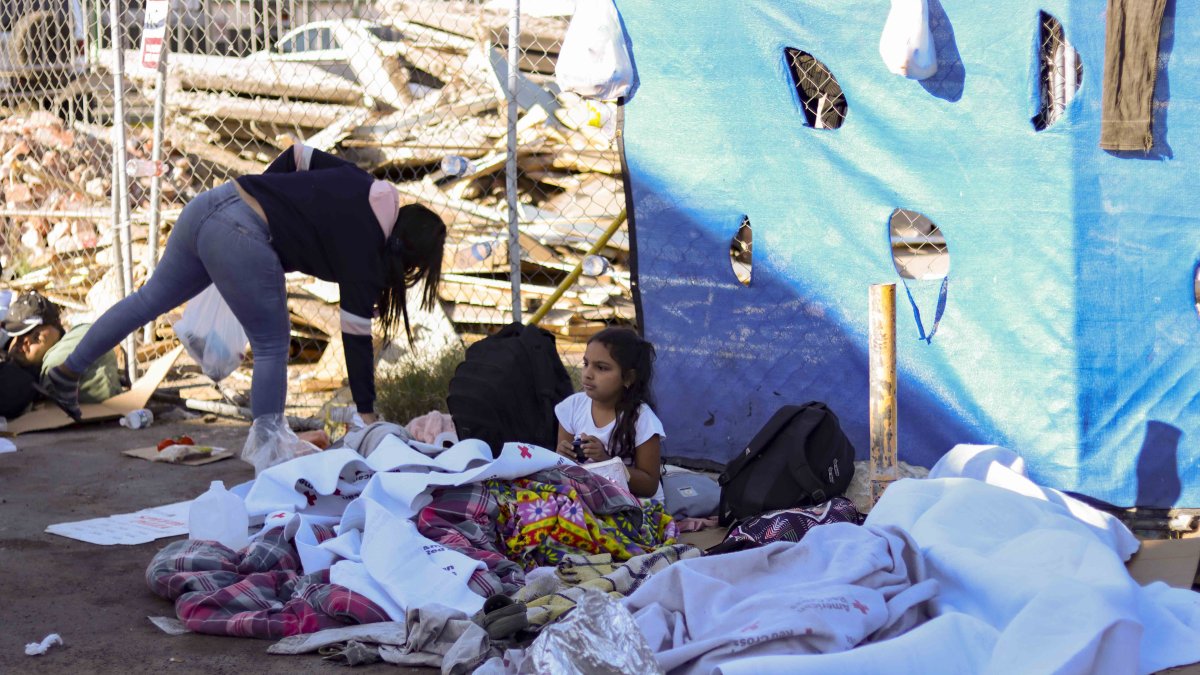 Los migrantes tratan de protegerse con plástico y cobijas  en la zona fronteriza.