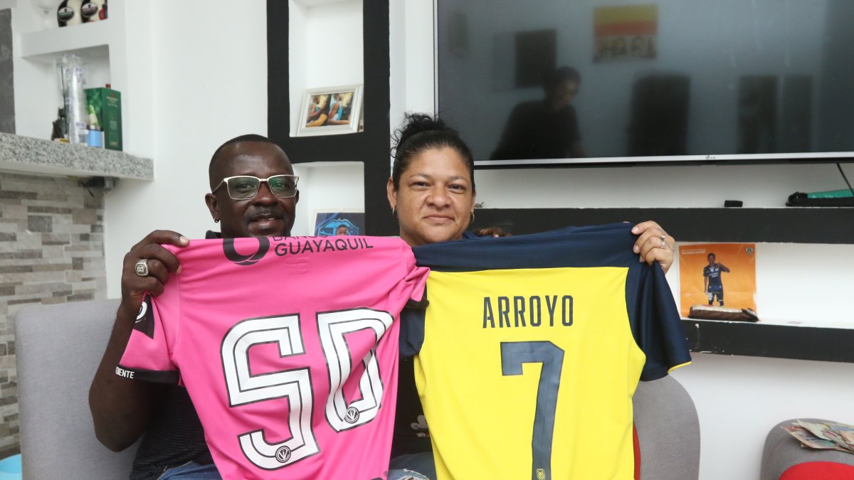 Silvia Alvarado y Grober Arroyo sostienen con orgullo las camisetas de su hijo Kenny Arroyo.