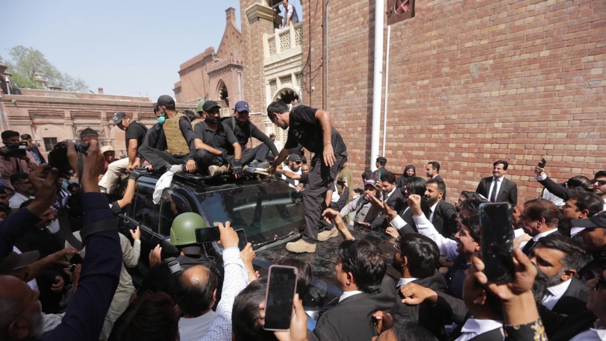 Seguidores del ex primer ministro escoltan en Lahore (Pakistán) a su líder Imran Khan y su esposa Bushra Bibi a su llegada ante el tribunal tras un controvertido arresto con violencia.