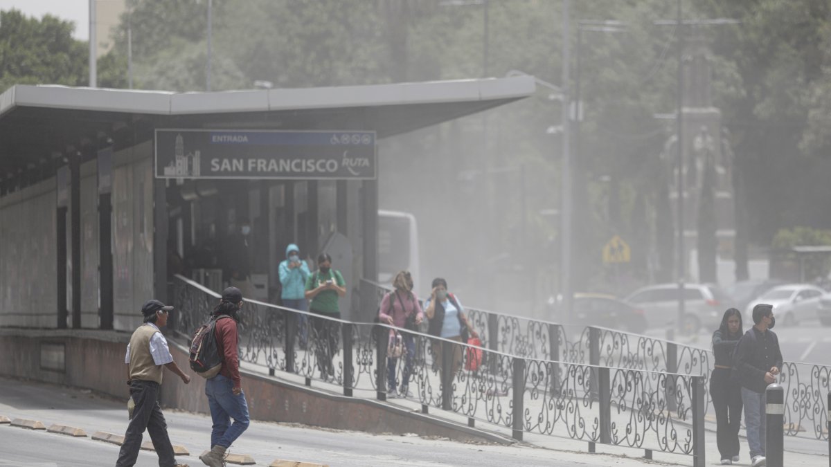 Transeúntes caminan entre la ceniza ocasionada por la actividad del volcán Popocatépetl, hoy, en el estado de Puebla (México).