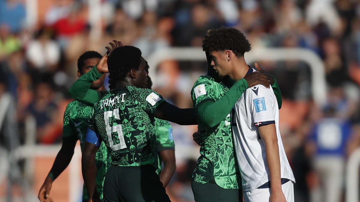 Los jugadores de Nigeria consuelan a un rival de República Dominicana al finalizar el partido.