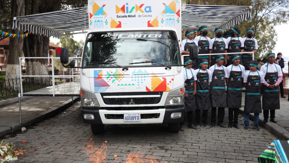 Estudiantes de gastronomía posan delante la escuela móvil de cocina 'Miska', 'en La Paz (Bolivia).