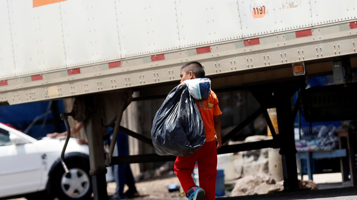 Un niño carga una bolsa negra donde lleva botes plásticos para reciclar en Olancho (Honduras), en una fotografía de archivo.