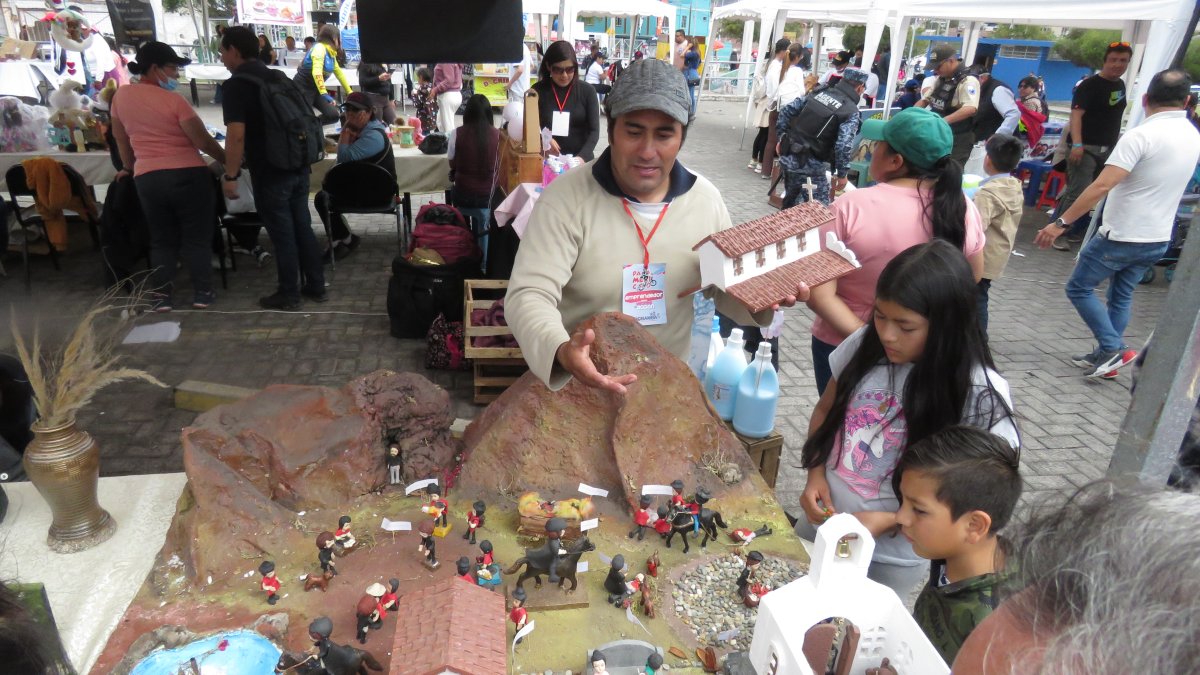 Riobamba. Varios niños se acercan a observar las recreaciones que se exhiben en una feria.