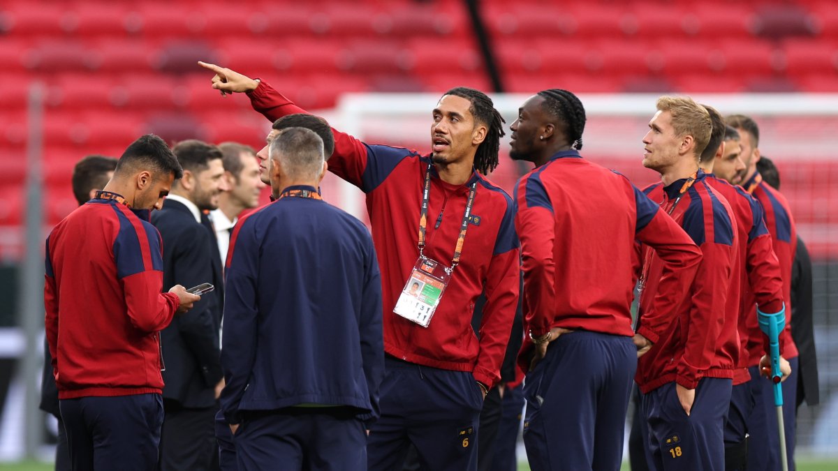 Chris Smalling de Roma (C) habla con sus compañeros de equipo en el campo del Puskas Arena en Budapest, Hungría.
