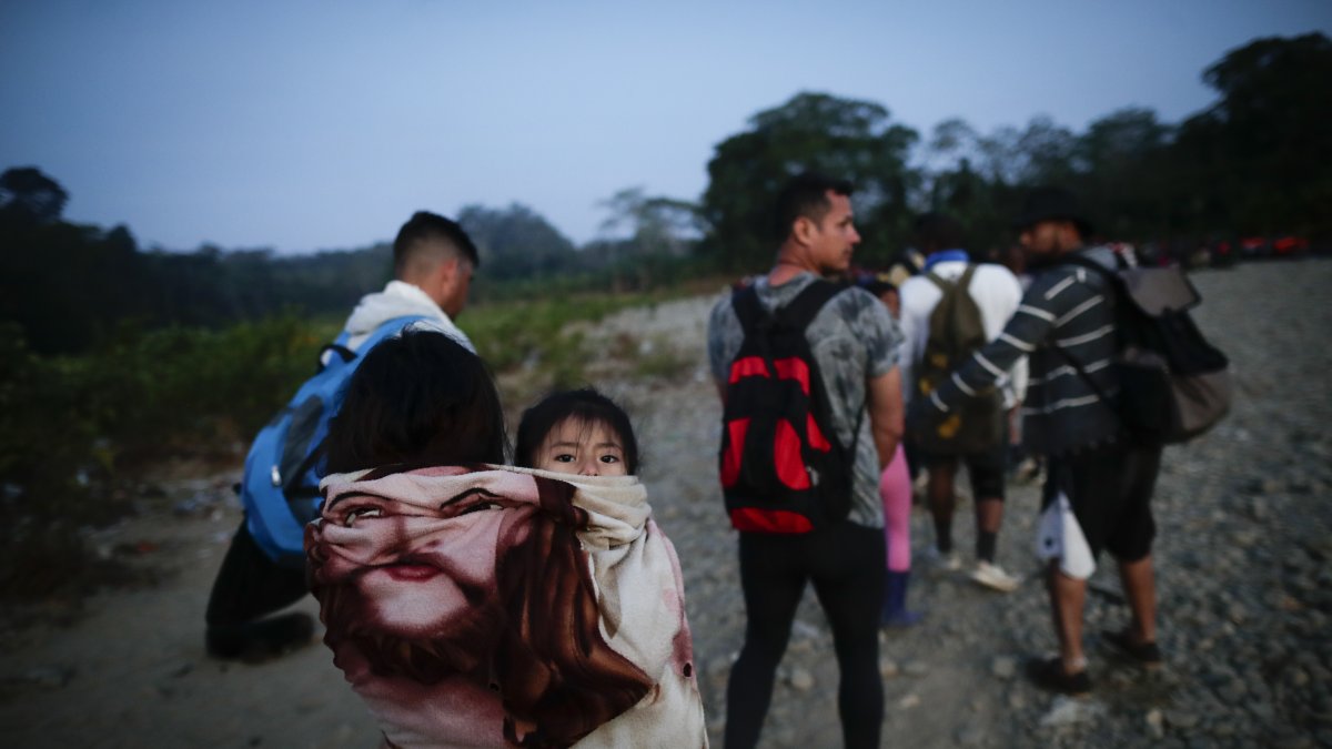 Adultos y niños migrantes hacen fila en la comunidad de Bajo Chiquito para ser trasladados a la Estación de Recepción Migratoria (ERM) de San Vicente, en Metetí (Panamá), .