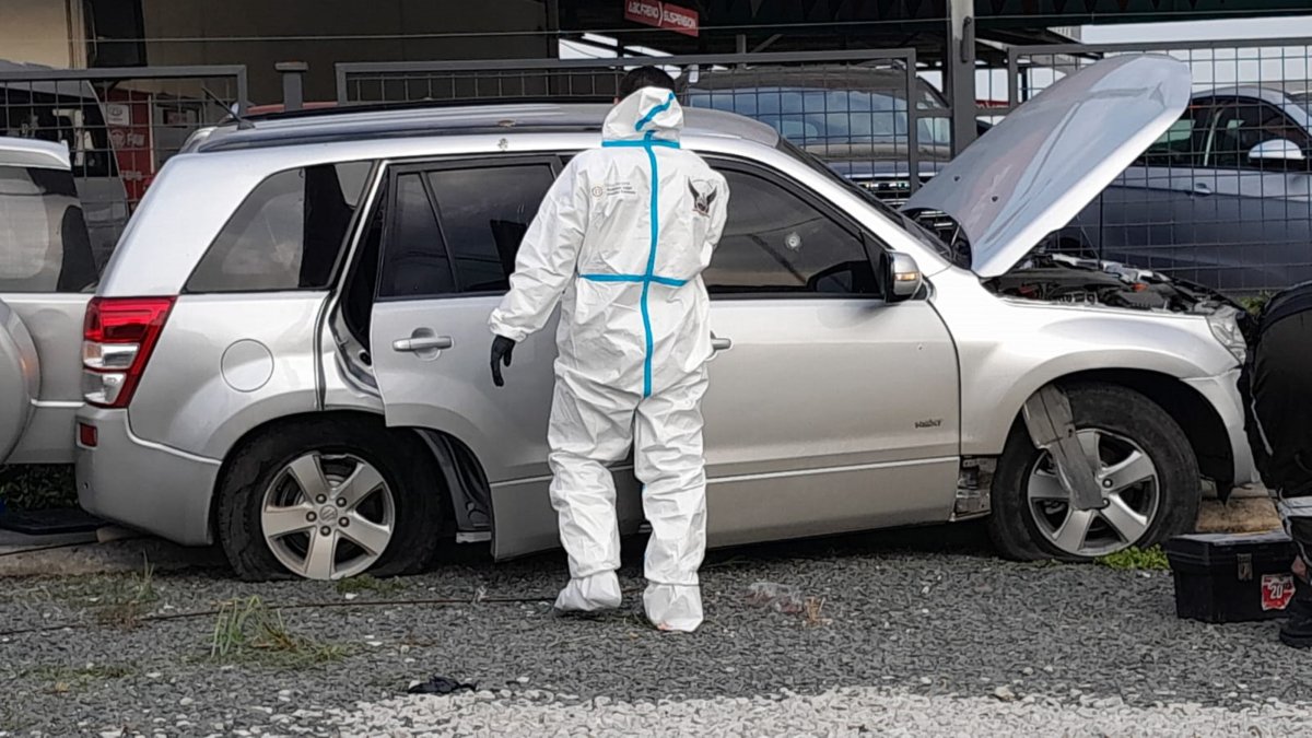 Un agente revisa el vehículo en el que se movilizaba el agente de tránsito y un acompañante.