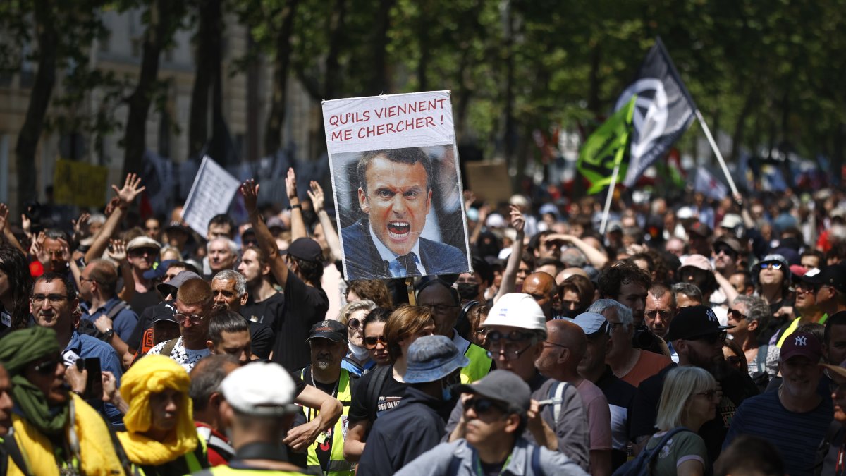 Manifestantes sostienen una imagen del presidente Emmanuel Macron durante protestas en París contra la reforma a las pensiones que impulsa el Ejecutivo.