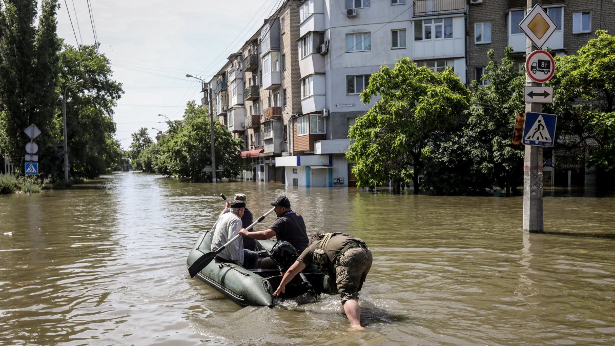 Personas se mueven en un bote inflable por las calles de la inundada ciudad de Jerson, este miércoles 7 de junio.
