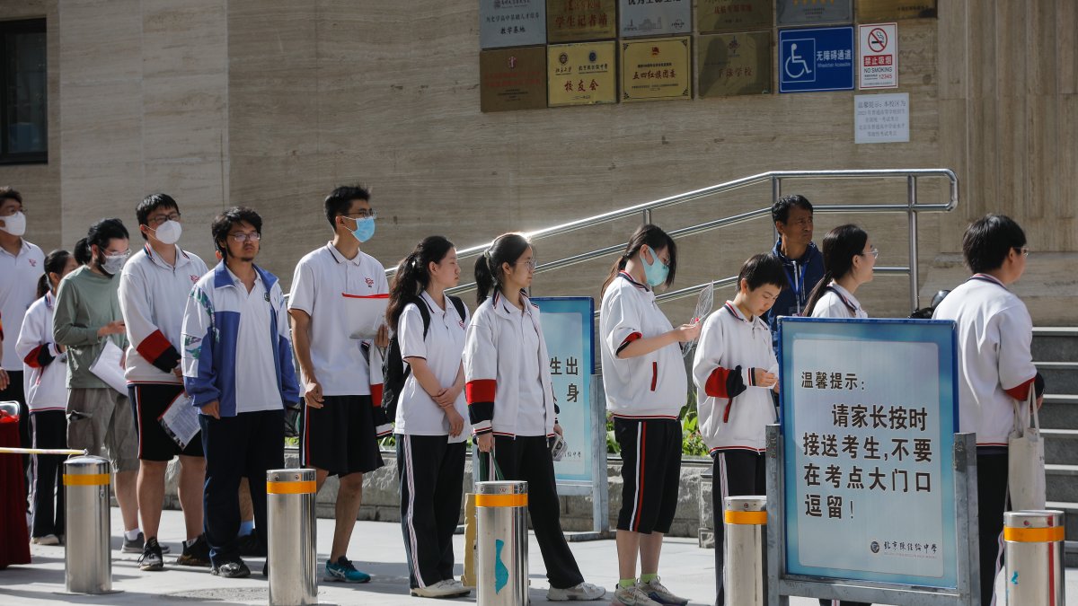 Estudiantes chinos hacen fila en una escuela de Pekín para entrar al examen anual de ingreso a la universidad