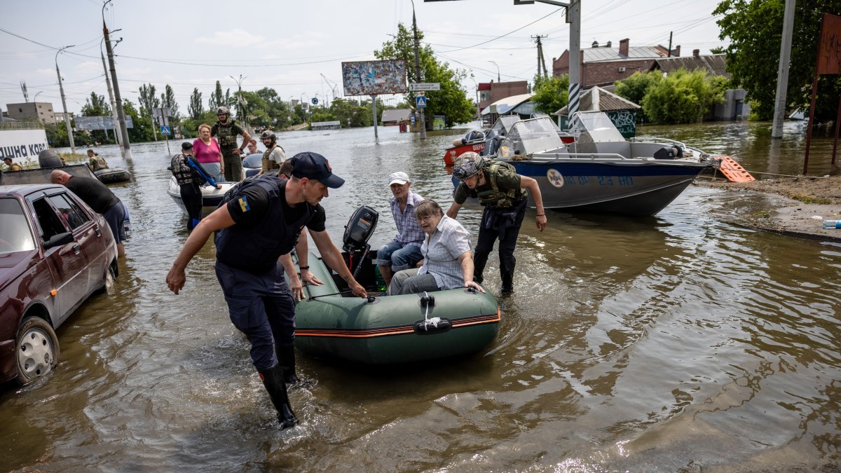 Los equipos de rescate evacuan a los residentes de una plaza inundada en Kherson, Ucrania, el 8 de junio de 2023, en medio de la invasión rusa. Ucrania acusó a las fuerzas rusas de destruir una presa