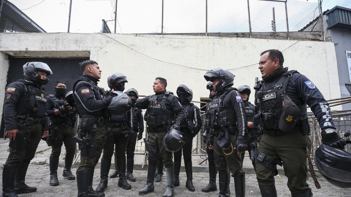 Integrantes de la policía nacional de Ecuador esperan hoy, frente a la cárcel de El Inca, en Quito (Ecuador)