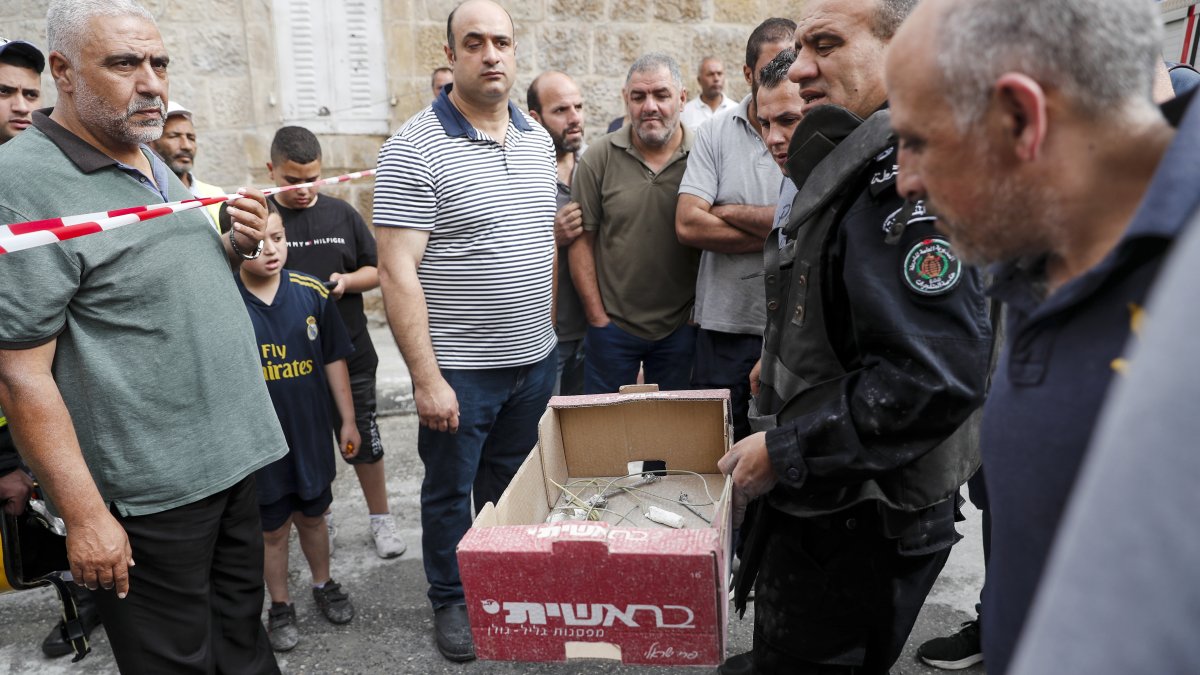  Un experto en explosivos palestino lleva una caja cerca de la casa destruida del preso palestino Islam Froukh, que fue demolida por las fuerzas israelíes.