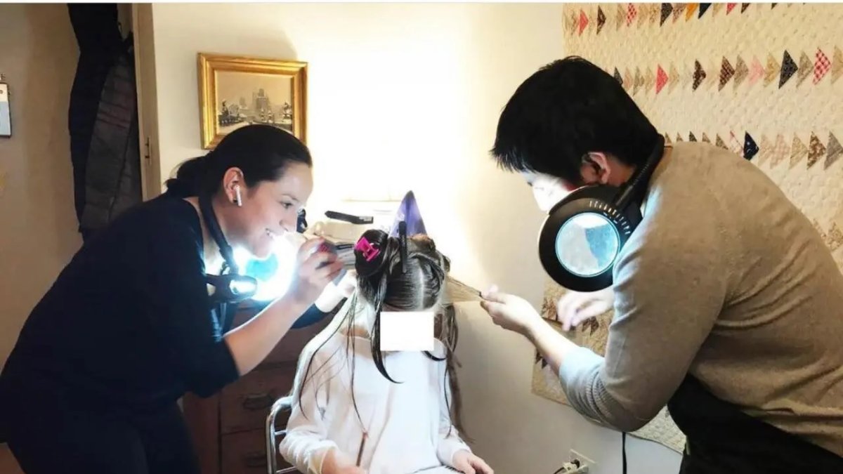 La ecuatoriana Eliana junto a un compañero de labores realiza el tratamiento contra la infestación de piojos de una niña en Nueva York.