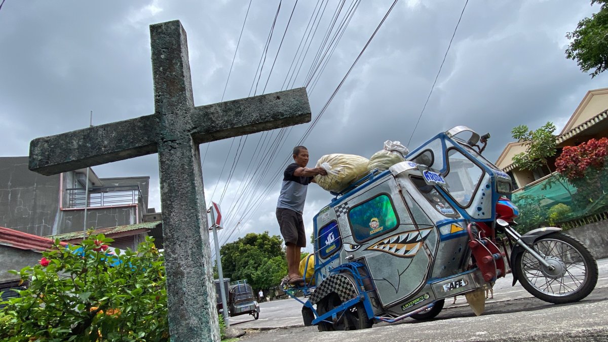Un hombre mete sus pertenencias en su moto de tres ruedas durante la evacuación de las inmediaciones del volcán Mayón, al este de la isla filipina de Luzón,