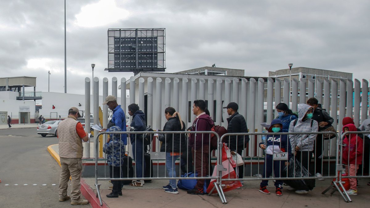 Migrantes hacen fila afuera de la garita internacional del Chaparral, el 10 de junio de 2023, en la ciudad fronteriza de Tijuana (México).