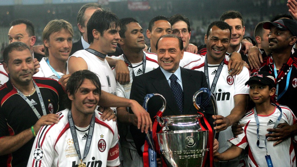 Silvio Berlusconi, presidente del AC Milán, sostiene junto a sus jugadores el trofeo de campeones.