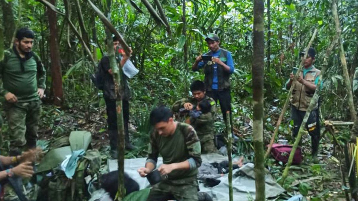 Fotografía cedida hoy por las Fuerzas Militares de Colombia que muestra a soldados e indígenas mientras atienden a los niños rescatados tras 40 días en la selva, en Guaviare (Colombia).