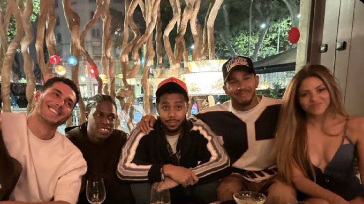 Shakira junto a Lewis Hamilton y un grupo de amigos celebrando en un restaurante.