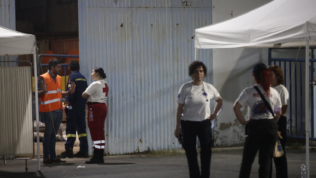 Imagen de voluntarios junto al almacén donde son tratados los supervivientes del naufragio este miércoles en el Mar Jónico de un pesquero con cientos de migrantes a bordo. EFE/EPA/YANNIS KOLESIDIS