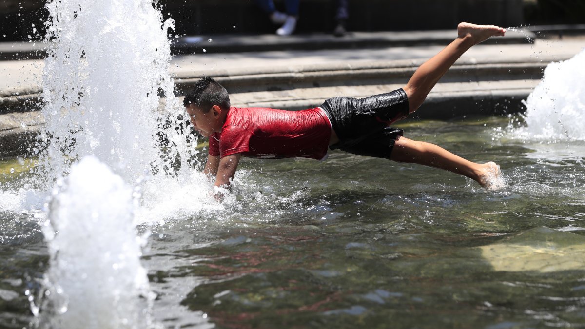 Un niño se refresca en una pileta tras la sofocante ola de calor