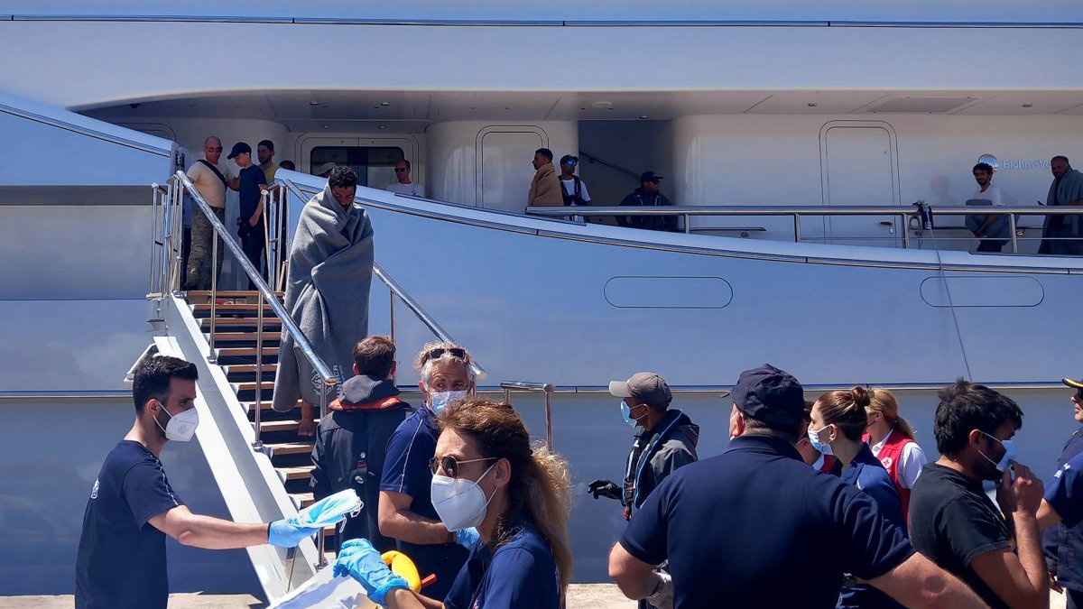 Paramédicos del Servicio Nacional de Ambulancias de Emergencia (EKAV) de Grecia y miembros de la Cruz Roja griega ayudan a los migrantes a su llegada al puerto de Kalamata, Grecia